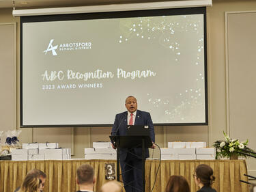 Superintendent stands on stage to give introduction