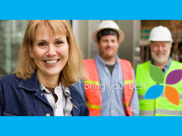 woman smiling with construction staff behind