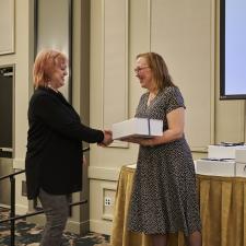 Trustee Wilson gifting a long service service gift box to a female employee