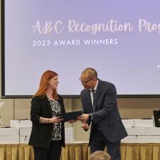 Woman receives recognition certificate on stage