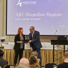 Woman receives recognition certificate on stage