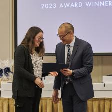 Woman receives recognition certificate on stage