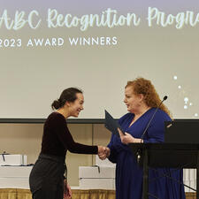 Woman receives recognition certificate on stage