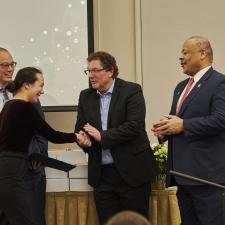 Woman shakes hands after receiving award